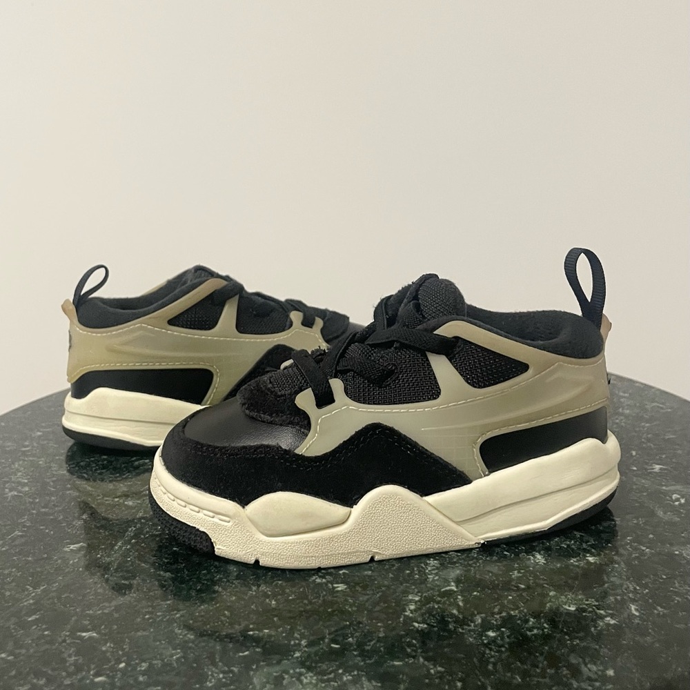 Jordan 4 RM Baby/Toddler shoes in a black and coconut milk colorway